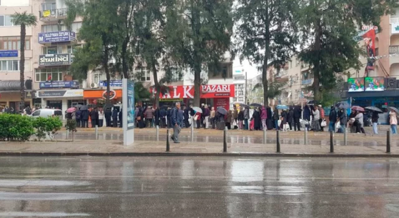 Buca'da, vatandaşlar yağmur altında askıda ekmek kuyruğunda