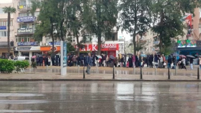 Buca'da, vatandaşlar yağmur altında askıda ekmek kuyruğunda