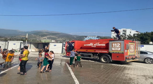 Hatay’da konteyner kentteki öğrenciler itfaiyenin sıktığı suyla serinledi